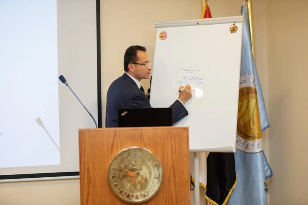Prof. Hazem Halim writing on whiteboard